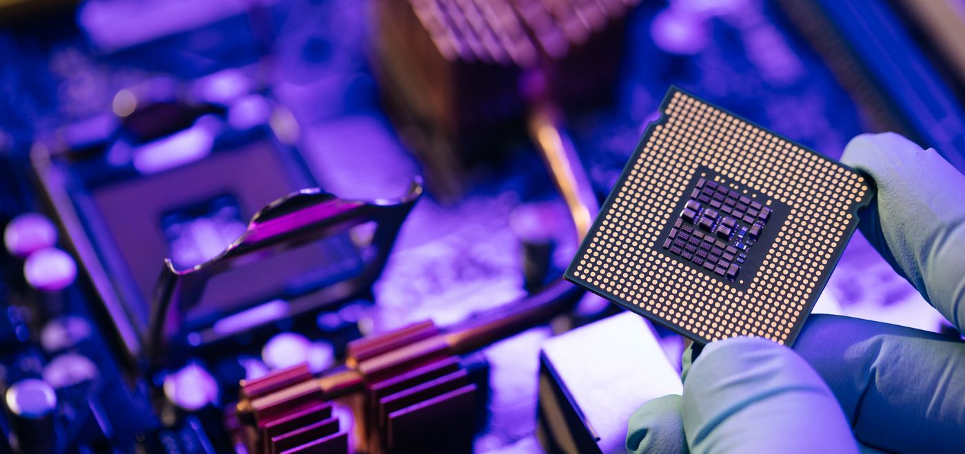 Engineer showing a computer microchip on motherboard background. Electronic circuit board with processor